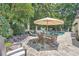 Outdoor seating area with umbrella next to a beautiful pool and lush landscaping at 111 Cherry Hill Dr, Marietta, GA 30067