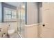 Bathroom with wainscoting, features a tiled shower with a glass door and a shuttered window for natural light at 111 Cherry Hill Dr, Marietta, GA 30067