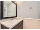 A stylish powder room featuring a marble countertop and black framed mirror, with a wainscotted lower wall at 111 Cherry Hill Dr, Marietta, GA 30067