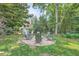 Backyard firepit area featuring a stone base surrounded by mature trees and landscaping at 111 Cherry Hill Dr, Marietta, GA 30067