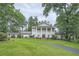 Stately white brick home with mature trees, a manicured lawn, and a circular driveway exudes classic elegance at 111 Cherry Hill Dr, Marietta, GA 30067