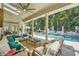 Covered outdoor patio with comfortable seating overlooking the pool and lush backyard at 111 Cherry Hill Dr, Marietta, GA 30067