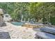 Backyard pool and spa area featuring lounge chairs and an outdoor patio with mature trees at 111 Cherry Hill Dr, Marietta, GA 30067