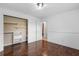Cozy bedroom with wood floors, built-in closet shelving, and an open doorway to the hall at 1647 Grandeus Sw Ln, Stone Mountain, GA 30087