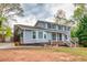 This two-story home features a covered front porch, gray siding, and a driveway at 1647 Grandeus Sw Ln, Stone Mountain, GA 30087