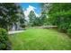 Lush backyard with hot tub, pergola seating area, level lawn, and mature trees at 2001 Mclain Nw Rd, Acworth, GA 30101