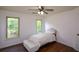 Cozy bedroom features hardwood floors, two windows, and a bench at the foot of the bed at 2001 Mclain Nw Rd, Acworth, GA 30101