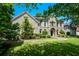 Beautiful brick home with arched entryway, mature trees, and manicured front lawn at 2001 Mclain Nw Rd, Acworth, GA 30101