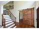 Elegant foyer featuring a staircase, dark hardwood floors, and a sliding barn door at 2001 Mclain Nw Rd, Acworth, GA 30101