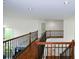 Second-floor hallway with hardwood floors, decorative iron railings, and neutral paint at 2001 Mclain Nw Rd, Acworth, GA 30101