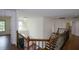 Second-floor hallway featuring hardwood floors, decorative iron railings, and chandelier lighting at 2001 Mclain Nw Rd, Acworth, GA 30101