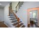 Elegant staircase featuring hardwood steps with decorative iron railings to the upper floor at 2001 Mclain Nw Rd, Acworth, GA 30101