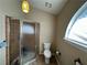 Neutral toned bathroom with a glass shower and toilet under an awning window at 3889 Sidney Lanier Blvd, Duluth, GA 30096