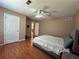 Neutral toned bedroom with a ceiling fan, wood floors, and two white paneled doors at 3889 Sidney Lanier Blvd, Duluth, GA 30096