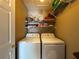 Efficient laundry room with washer, dryer, and storage shelves for organization and convenience at 3889 Sidney Lanier Blvd, Duluth, GA 30096