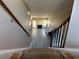 View down carpeted stairs to the open living area with a fireplace and natural light at 3889 Sidney Lanier Blvd, Duluth, GA 30096