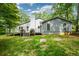 View of the home's back exterior featuring a wood deck, siding, chimney, and a lush green lawn at 4766 Jamerson Forest Cir, Marietta, GA 30066