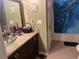 Bathroom features a granite sink, shower with blue curtain, and a toilet at 1130 Monfort Rd, Lawrenceville, GA 30046
