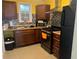 Bright kitchen with stainless steel appliances, dark cabinets, and a window above the sink at 1130 Monfort Rd, Lawrenceville, GA 30046
