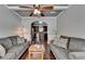 Open concept living room with hardwood floors, gray sofas, and an arched doorway to the kitchen at 2020 Walking Horse Trl, Cumming, GA 30041