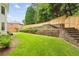 Expansive backyard featuring a well-manicured lawn, wooden retaining walls, and mature trees at 505 Woodmoore Ct, Sandy Springs, GA 30342