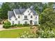 Stunning two-story white home with lush landscaping, offering timeless elegance and curb appeal at 505 Woodmoore Ct, Sandy Springs, GA 30342