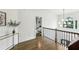 Upstairs hallway with hardwood floors, modern lighting, and view into a bedroom at 505 Woodmoore Ct, Sandy Springs, GA 30342