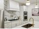 Modern kitchen featuring marble backsplash, stainless steel appliances, and a large center island at 505 Woodmoore Ct, Sandy Springs, GA 30342