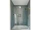 Modern shower with a herringbone tile pattern, glass enclosure, and rainfall shower head at 505 Woodmoore Ct, Sandy Springs, GA 30342