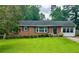 Charming brick home with a well-manicured lawn and lush greenery at 1468 Spruce Se Dr, Smyrna, GA 30080