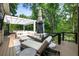Spacious outdoor patio boasts plush seating and a lounge chair surrounded by natural wooded scenery at 1164 Bonview Ne Ln, Atlanta, GA 30324