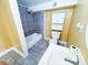 Well-lit bathroom featuring a tub-shower combo, tile flooring, and a storage cabinet at 241 Sarann Nw Ct, Lilburn, GA 30047