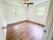 Bright bedroom with light wood floors, ceiling fan and windows with nature views at 241 Sarann Nw Ct, Lilburn, GA 30047