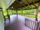 Large, covered deck with wood flooring and railing overlooks the green backyard at 241 Sarann Nw Ct, Lilburn, GA 30047