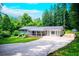 Charming single-story home with a long driveway and well-manicured lawn surrounded by lush trees at 241 Sarann Nw Ct, Lilburn, GA 30047