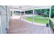 Spacious covered porch featuring wood-look tile flooring, white columns, and black metal railings at 241 Sarann Nw Ct, Lilburn, GA 30047