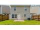 View of the back of the home, showcasing a grassy backyard with a wood fence at 256 Turnstone Rd, Stockbridge, GA 30281