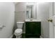 Cozy bathroom featuring a toilet, vanity with dark cabinets, framed mirror and light gray walls at 256 Turnstone Rd, Stockbridge, GA 30281