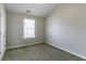 This bedroom has neutral walls, carpet, a window, and a closet at 256 Turnstone Rd, Stockbridge, GA 30281