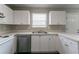 Well-lit kitchen boasts ample storage, stainless steel dishwasher and light countertops at 256 Turnstone Rd, Stockbridge, GA 30281