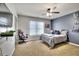 Modern bedroom featuring a dark accent wall, ceiling fan, and television for entertainment at 122 White Spruce Ct, Dallas, GA 30157