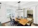 Bright dining room featuring a wooden table, modern lighting, and hardwood floors at 122 White Spruce Ct, Dallas, GA 30157