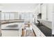 Open concept kitchen with white cabinetry, granite counters, and an adjacent dining area filled with light at 122 White Spruce Ct, Dallas, GA 30157