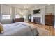Light filled bedroom with hardwood flooring, fireplace, chandelier, and large windows at 235 Founders Mill Ct, Roswell, GA 30075