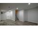 Well-lit basement features modern gray flooring and access to stairs at 515 Allens Landing Ct, Lawrenceville, GA 30045