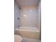 Bathtub and shower featuring an adjustable shower head and elegant floor-to-ceiling marble tiling at 515 Allens Landing Ct, Lawrenceville, GA 30045