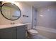 Charming bathroom features marble tiled shower/tub, dark hardware, and grey shaker cabinets at 515 Allens Landing Ct, Lawrenceville, GA 30045