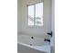 Close-up of a bathtub with dark fixtures and natural light from a nearby window at 515 Allens Landing Ct, Lawrenceville, GA 30045