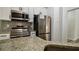 Close up shot of the stainless steel oven and refrigerator and granite counter top at 515 Allens Landing Ct, Lawrenceville, GA 30045