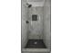 Modern bathroom shower featuring tiled walls, matte black fixtures, and a black hexagon tiled floor at 515 Allens Landing Ct, Lawrenceville, GA 30045